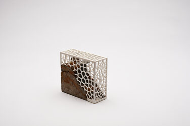 Award developed by students for the history of building made of naturally broken natural stone and a 3D-printed cellular structure, photographed diagonally