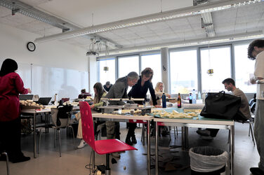 Blick in den Arbeitsraum mit Studierenden und Lehrenden der Summerschool mit Arbeitsmodellen und Kubaturen auf den Tischen.