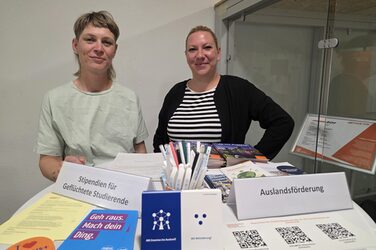 Zwei Personen stehen hinter einem Tisch mit verschiedenen Utensilien.