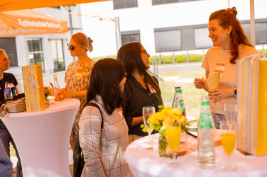 Several doctoral students chat during a party