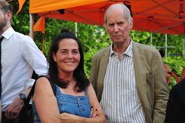 Zwei Lehrende unter dem orangefarbenen Pavillon der Fachschaft.