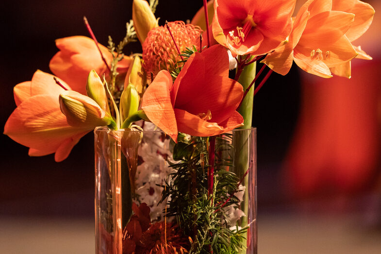 Foto von orangenen Blumen in einer Glasvase.