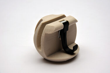 Design 9: circular model in beige made of generatively manufactured elements with a hook against a white background