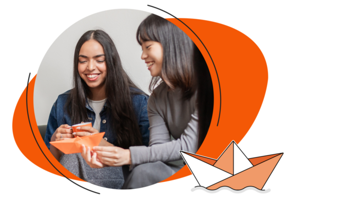 Zwei Studentinnen sitzen auf einem Sofa oder Sessel und lachen, während sie ein orangefarbenes Papierboot falten; daneben ist eine stilisierte Darstellung eines schwimmenden Papierboots zu sehen.