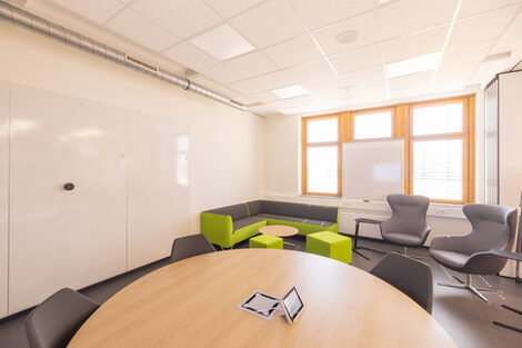 Room shot of the InnoLab, part of the room is shown here, with a view across a conference table to the "lounge area" with couch and armchairs.