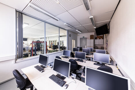 Room shot of the PC room. Next to it, visible through a pane of glass, is the laboratory for power electronics and drive systems. __