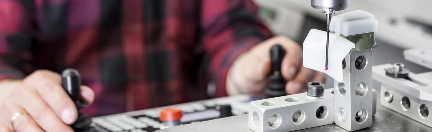 Photo of a person working with a 3D CNC coordinate measuring machine.