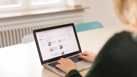 Photo of a student visits the Fachhochschule Dortmund website on her laptop. __ A student visits the Dortmund University of Applied Sciences website on her laptop.