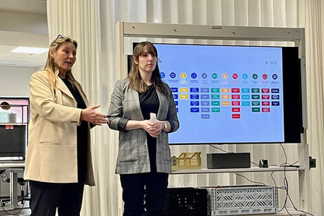 Prof. Dr. Sabine Sachweh und Olivia Nierobisch präsentieren auf einem großen Bildschirm das Projekt.