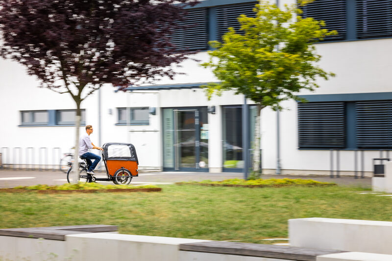 Photo Photo of a man riding a cargo bike on the FH campus.