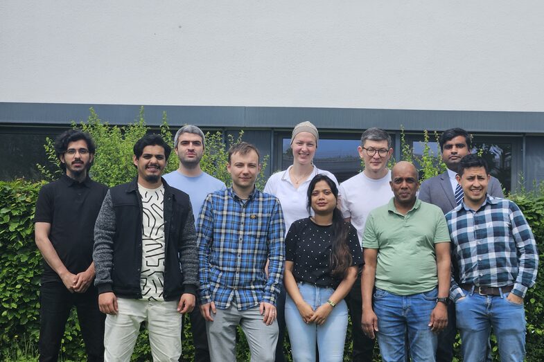 The photo shows 10 employees of the Emulate project in front of a building.