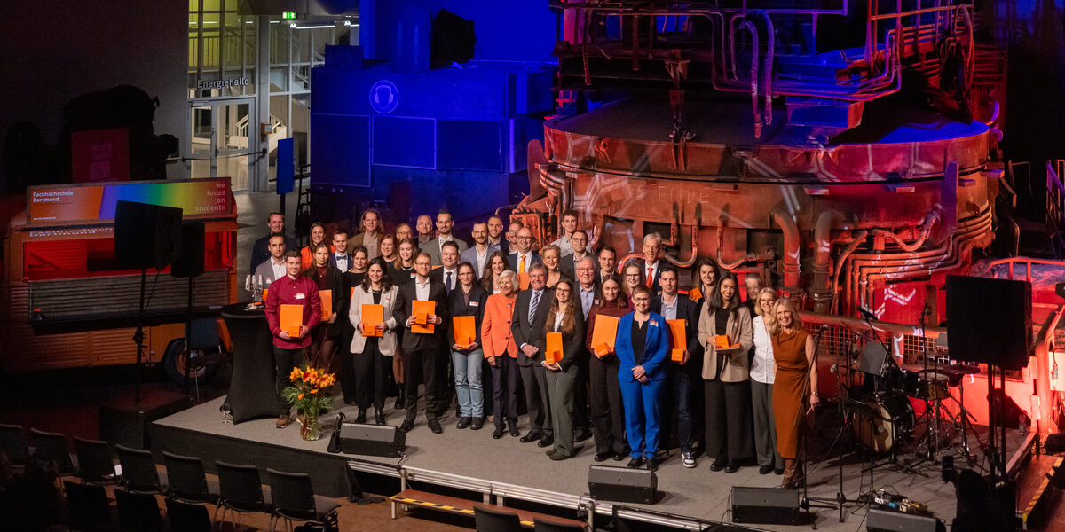 A large group of people stand on the stage.
