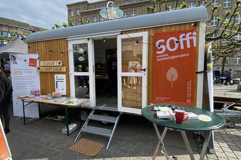 A converted construction trailer, which now serves as a mobile sustainability office, stands in a square for the exhibition.