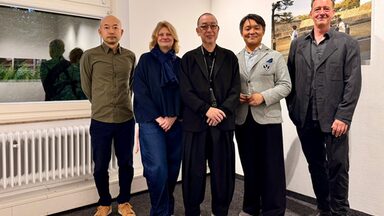 Five people in an interior look friendly towards the camera.
