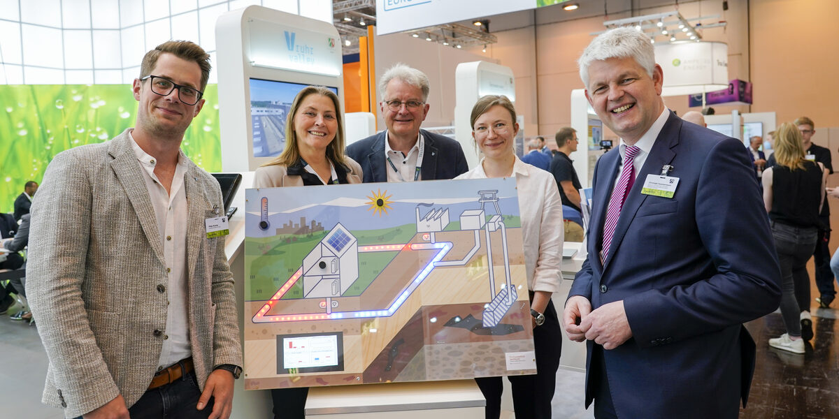 Group photo with Philip Wizenty (left), Prof. Dr. Sabine Sachweh (left) and other people at the MWIDE stand.