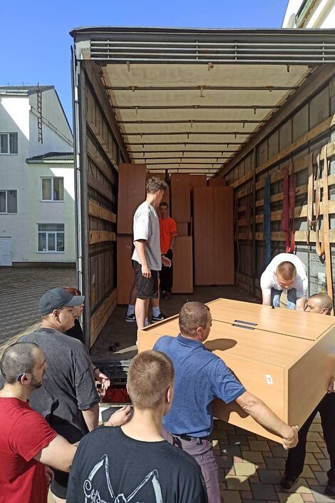 Möbel werden von Helfenden in der Ukraine ausgeladen