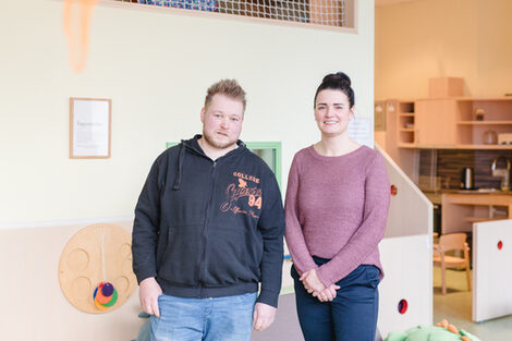 Zwei Personen stehen in einem Raum für Kinderbetreuung