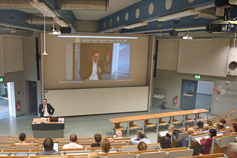 A person speaks in a lecture hall.