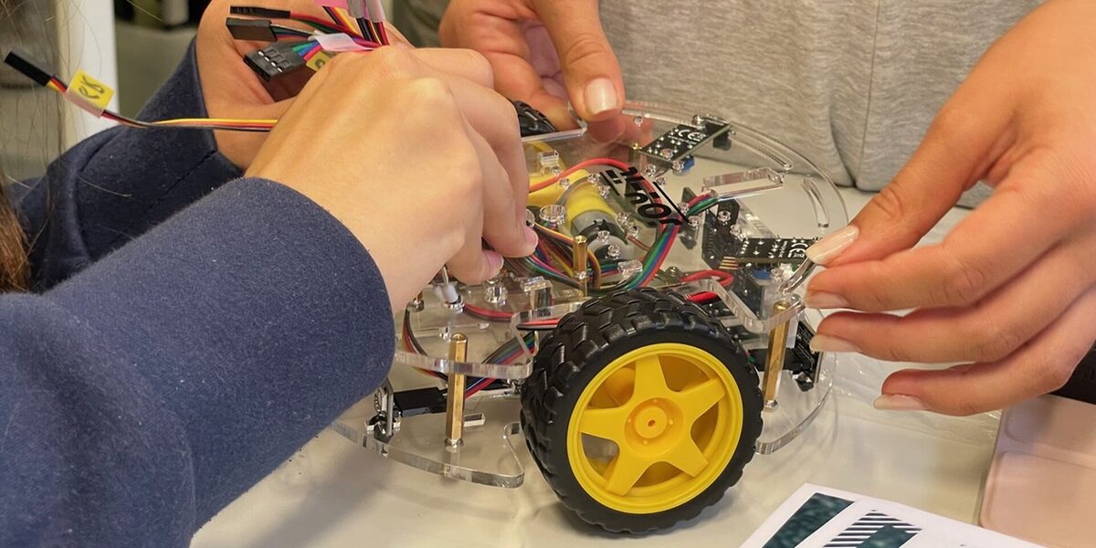Schüler*innen bauen an einem Modelauto.