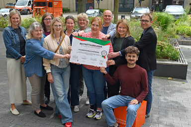 People stand together in a group and hold a large "Safe on duty" certificate