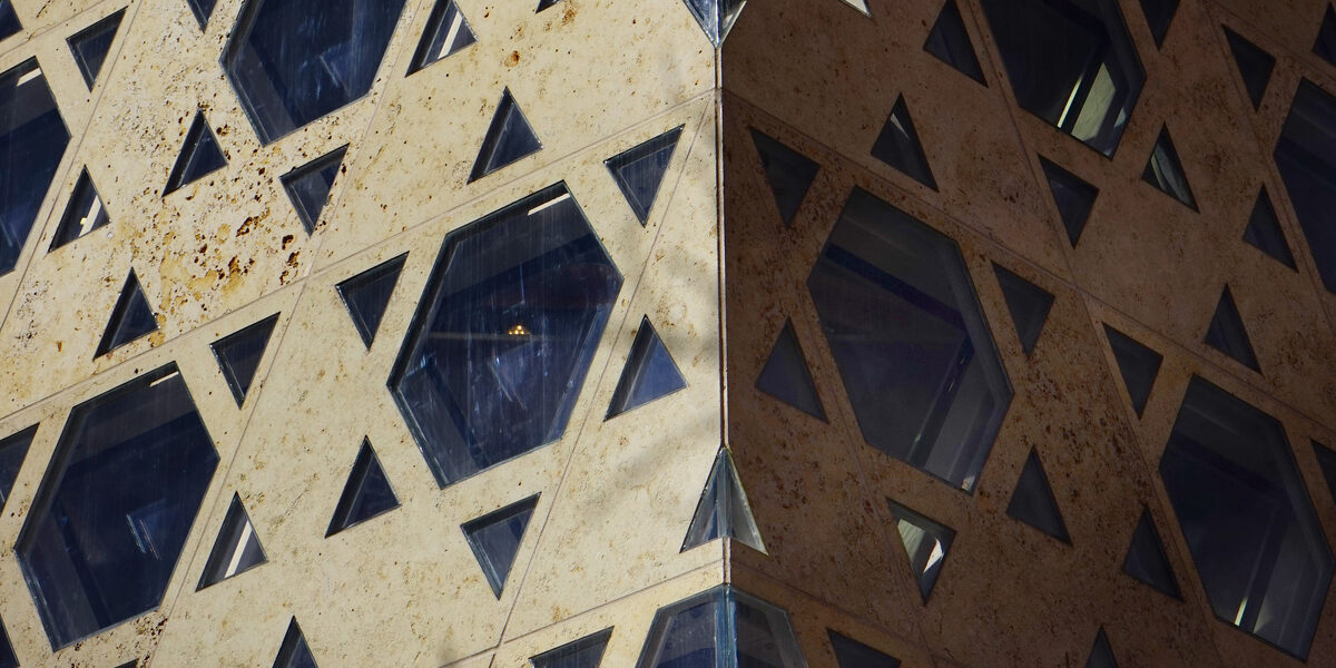 The outer wall of a synagogue with windows in the shape of the Star of David.