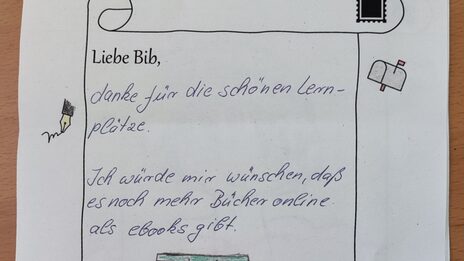 Foto von einem Brief an die Bibliothek mit einer Zeichnung von zwei gestapelten Büchern und dem Text: Liebe Bib, danke für die schönen Lernplätze. Ich würde mir wünschen, dass es noch mehr Bücher online als Ebooks gibt.__Photo of a letter to the library featuring a drawing of two books in a pile and the following text: Dear Library, thank you for the nice study desks. I wish more books were available online as e-books.