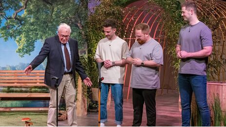 An older man shows how his walking stick remains standing on its own. Three young men look on.