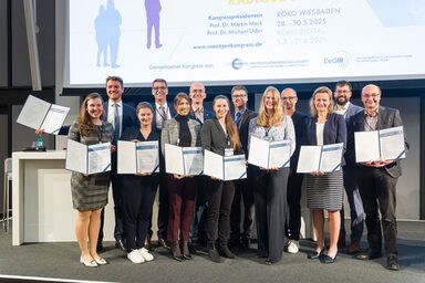 Gruppenbild mit mit mehreren Personen, die jeweils eine Urkunde vor sich halten.