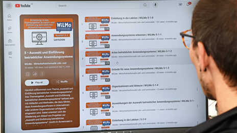 A person looks at a monitor showing the WiLMo project's YouTube channel.