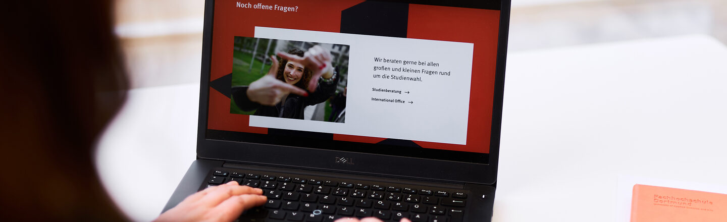 Foto über die Schulter einer Person, die am Laptop arbeitet. Auf dem Laptop ist die Folie einer Präsentation mit der Überschrift „Noch offene Fragen?“ aufgerufen.