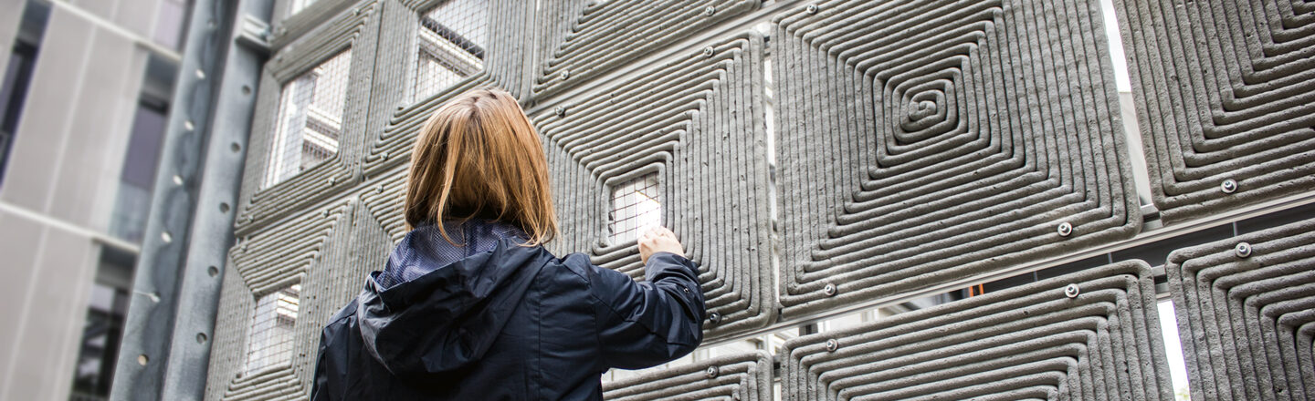 Close-up: A person stands in front of a robotically printed façade