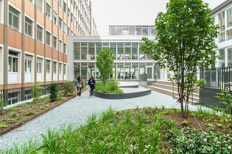 Photo of the inner courtyard at the student workplaces on Sonnenstraße. Two women are walking in the courtyard.