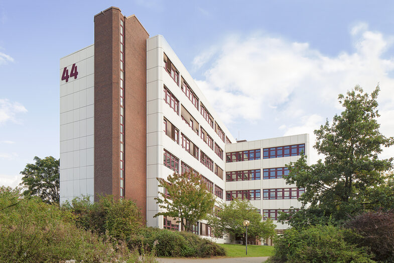 Foto vom Gebäude Emil-Figge-Straße 44 der Fachhochschule Dortmund, davor Büsche und Bäume.