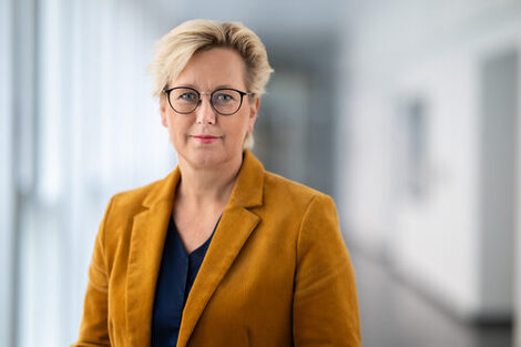 Auf dem Bild ist die Rektorin der FH Dortmund, Frau Prof. Dr. Tamara Appel abgebildet. Sie steht in einem Flur und schaut in die Kamera.