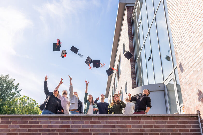 Alumni des Promotionskollegs werfen ihre Hüte in die Luft